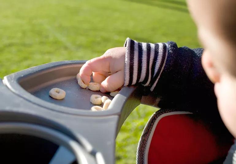 Infant demonstrating a pincer grasp to pick up small pieces of food